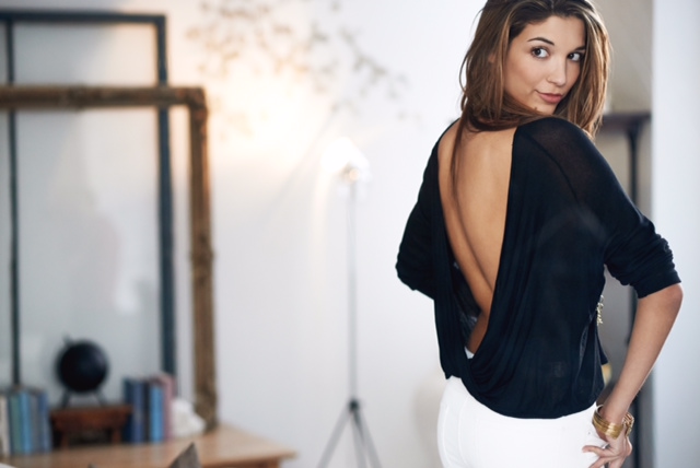 Woman in open-back black top glancing back