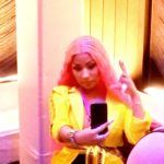 Person with pink hair in yellow jacket selfie