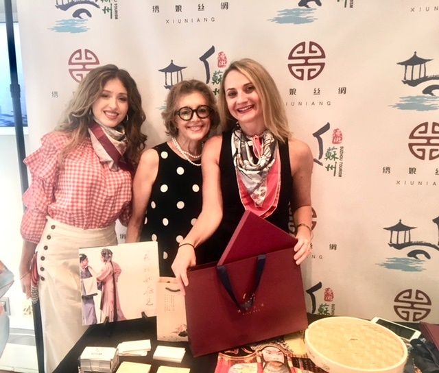 Three smiling women at promotional display