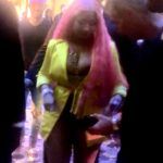 Person with pink hair wearing yellow jacket