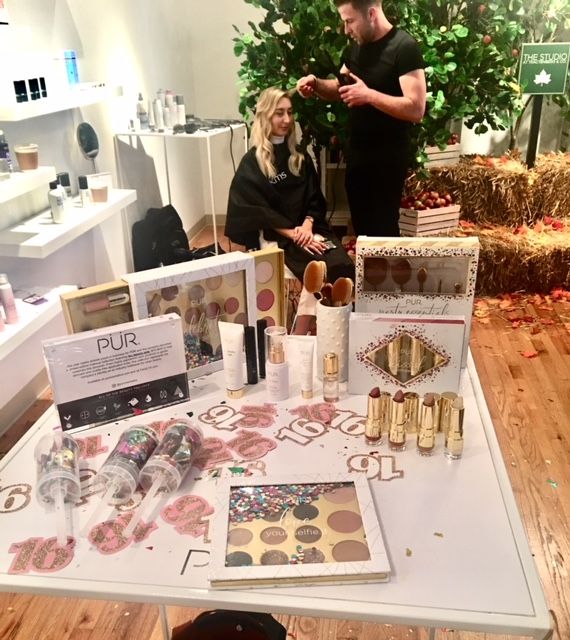 Makeup display with hairstylist styling client