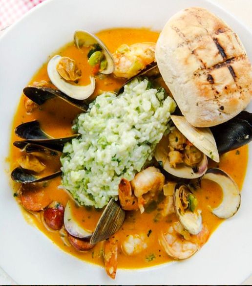 Seafood stew with green risotto and grilled bread