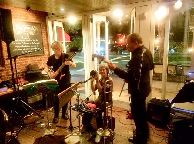 Three musicians performing in cozy restaurant