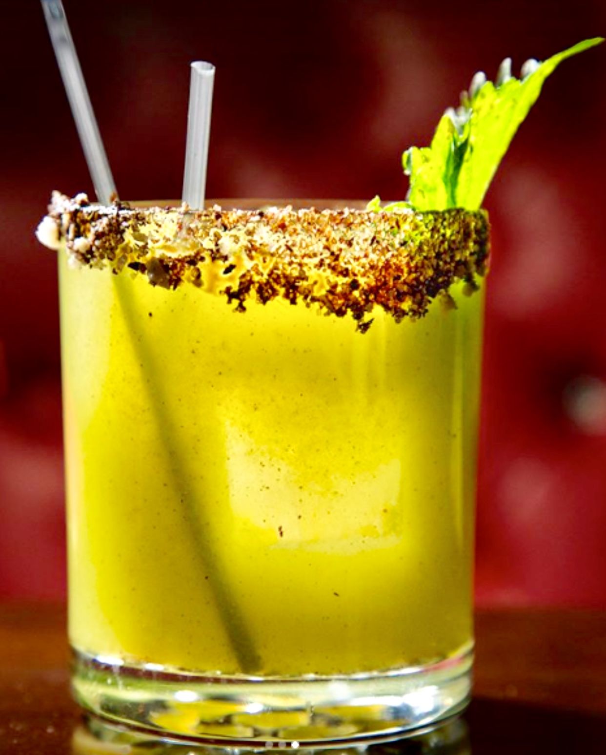 Green cocktail with spiced rim and celery