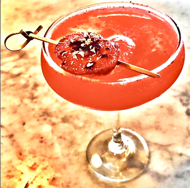 Pink cocktail in coupe glass with garnish