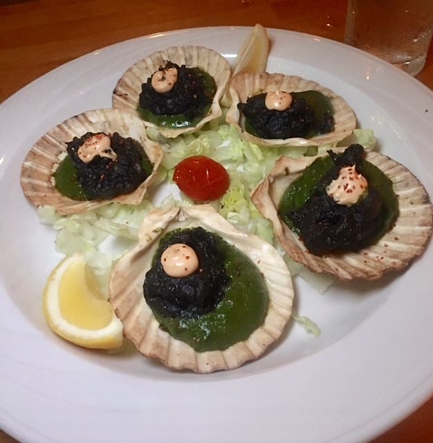 Scallop shells with dark topping and green sauce