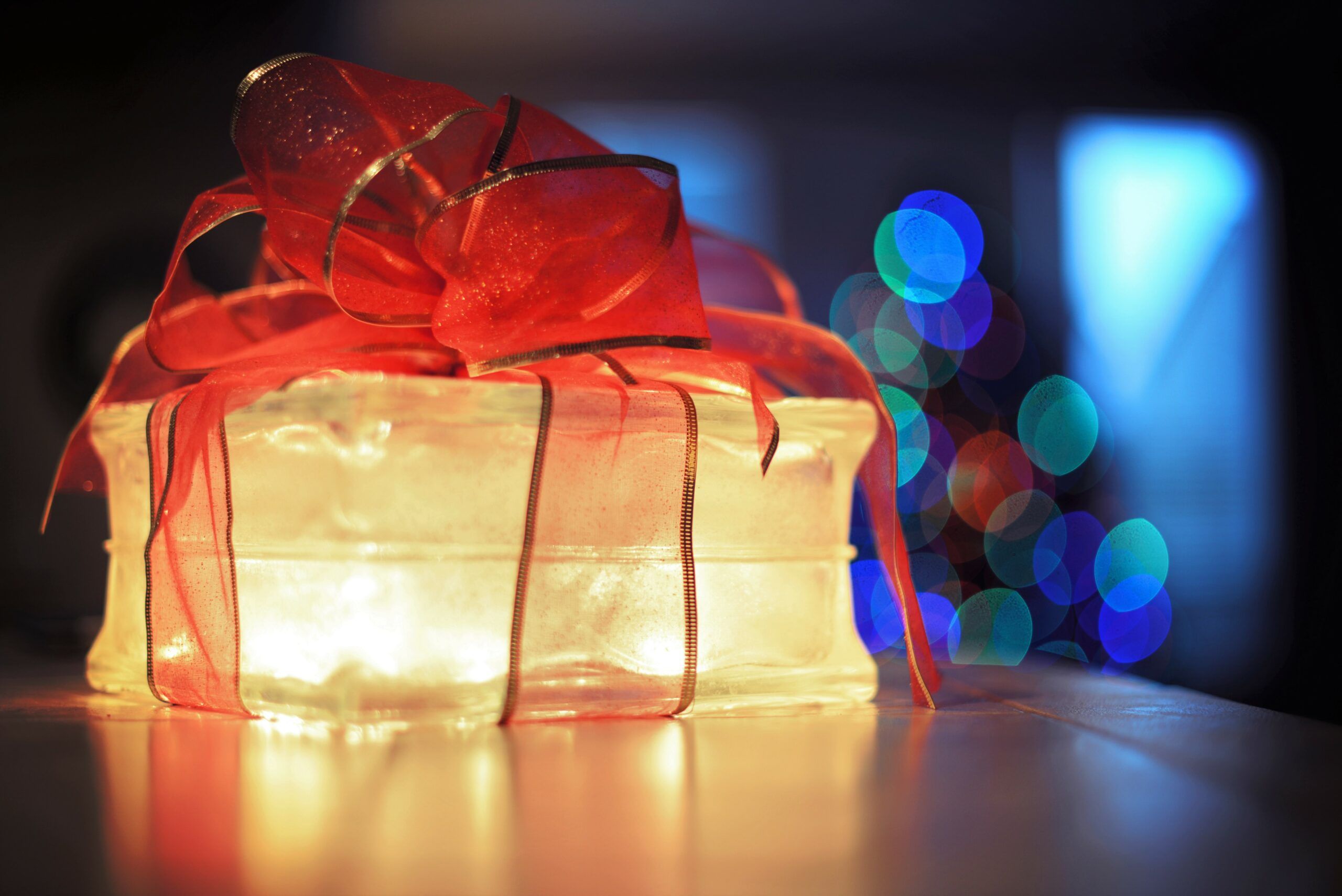 Illuminated Christmas gift box with red ribbon