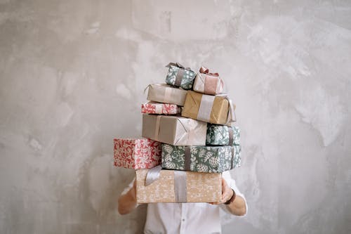 Person holding stacked wrapped gift boxes