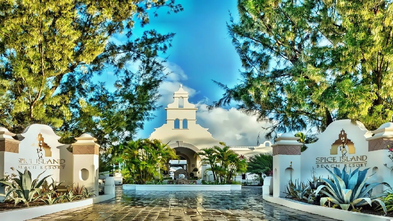 White arched tropical resort entrance with palms