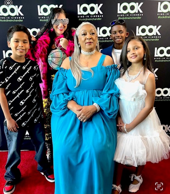 Woman in blue dress posing with children