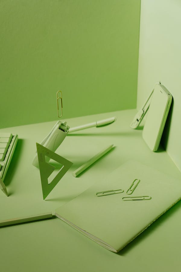 Green desk workspace with notebook and stationery