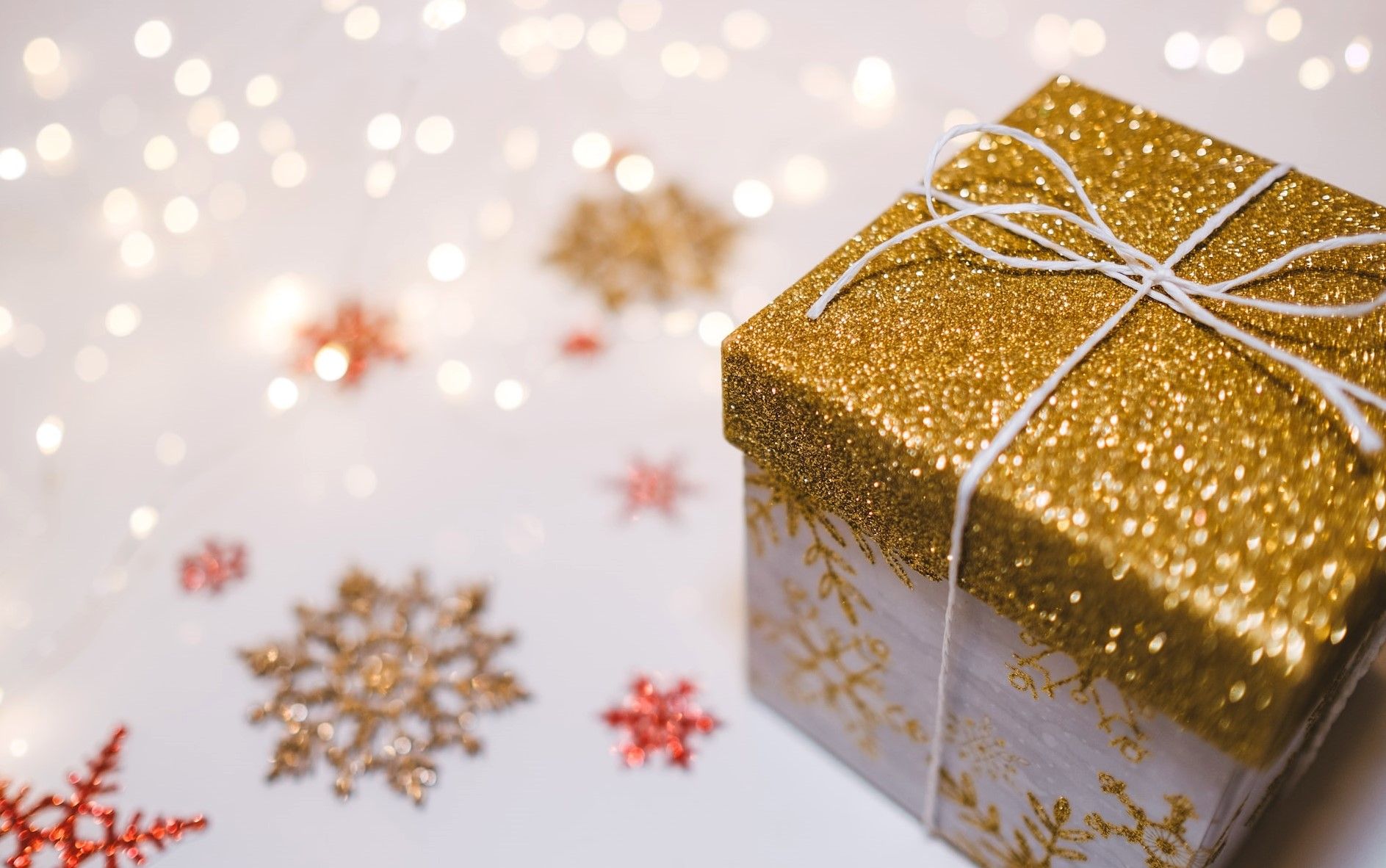 Gold glitter gift box with festive snowflakes