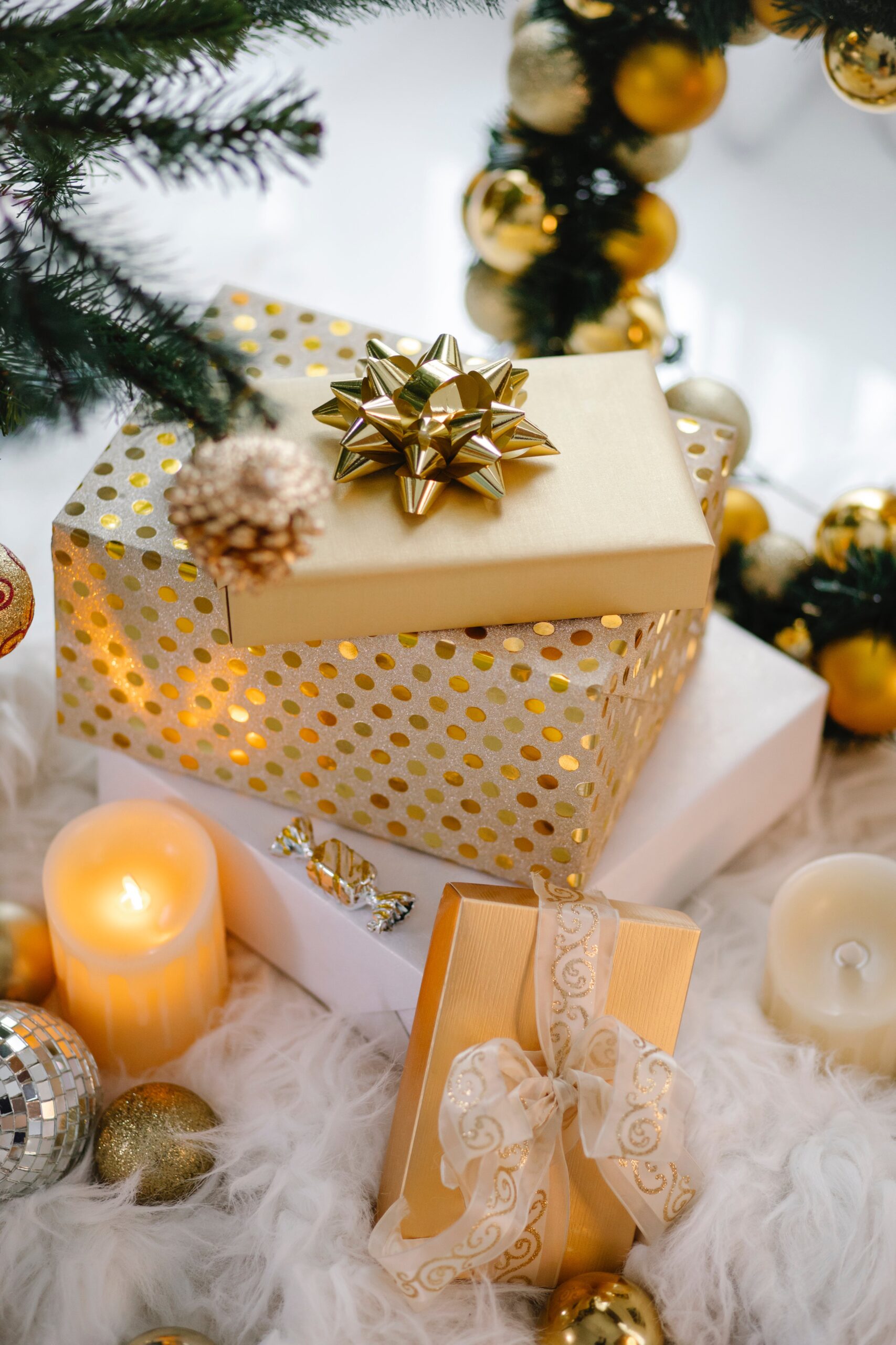 Gold-wrapped Christmas gifts with ribbons and candles