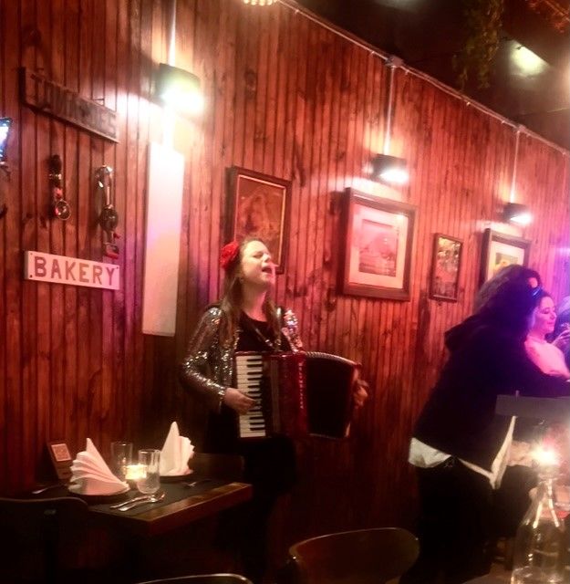 Accordion player performing in wood-paneled restaurant