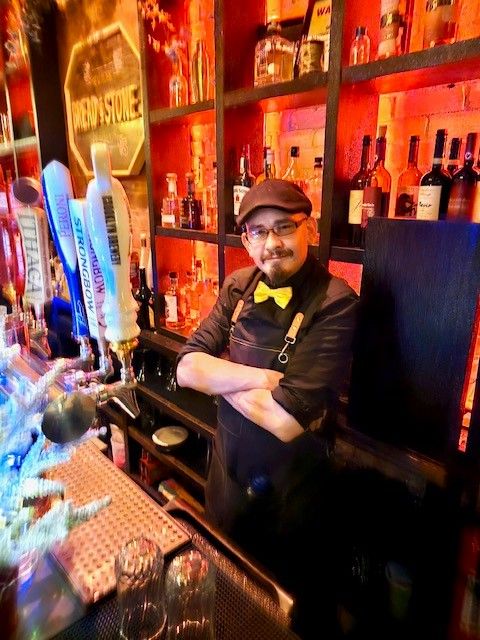 Bartender with yellow bow tie by beer taps