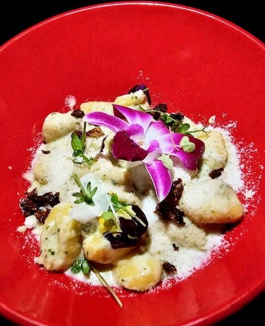 Gnocchi in cream sauce with edible orchid