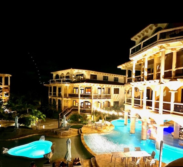 Illuminated resort hotel with swimming pools at night