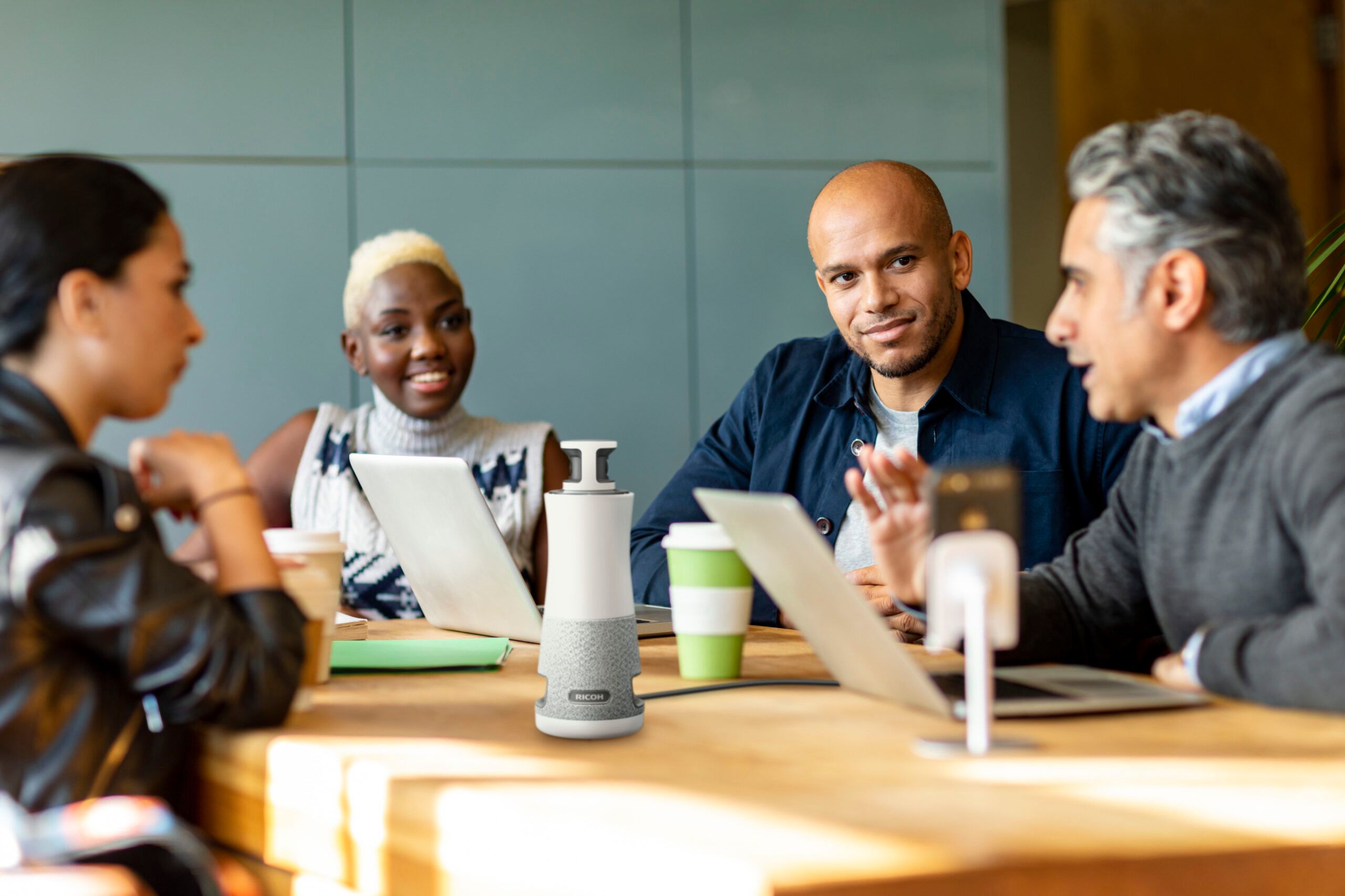 People collaborating at table with speakerphone