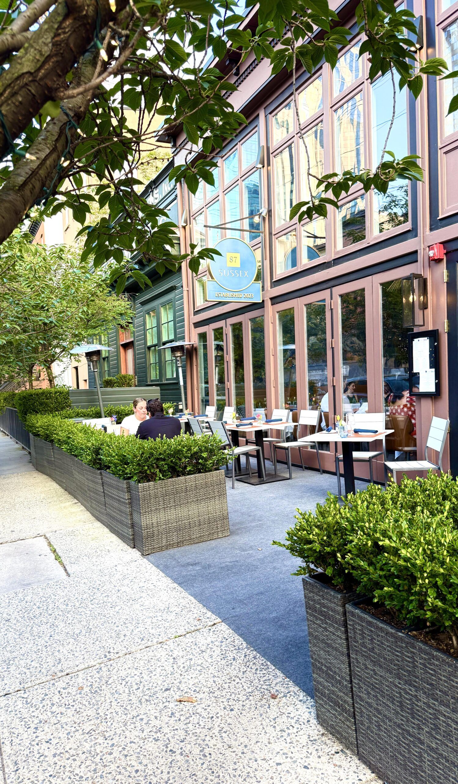 Outdoor sidewalk cafe with planters and seating