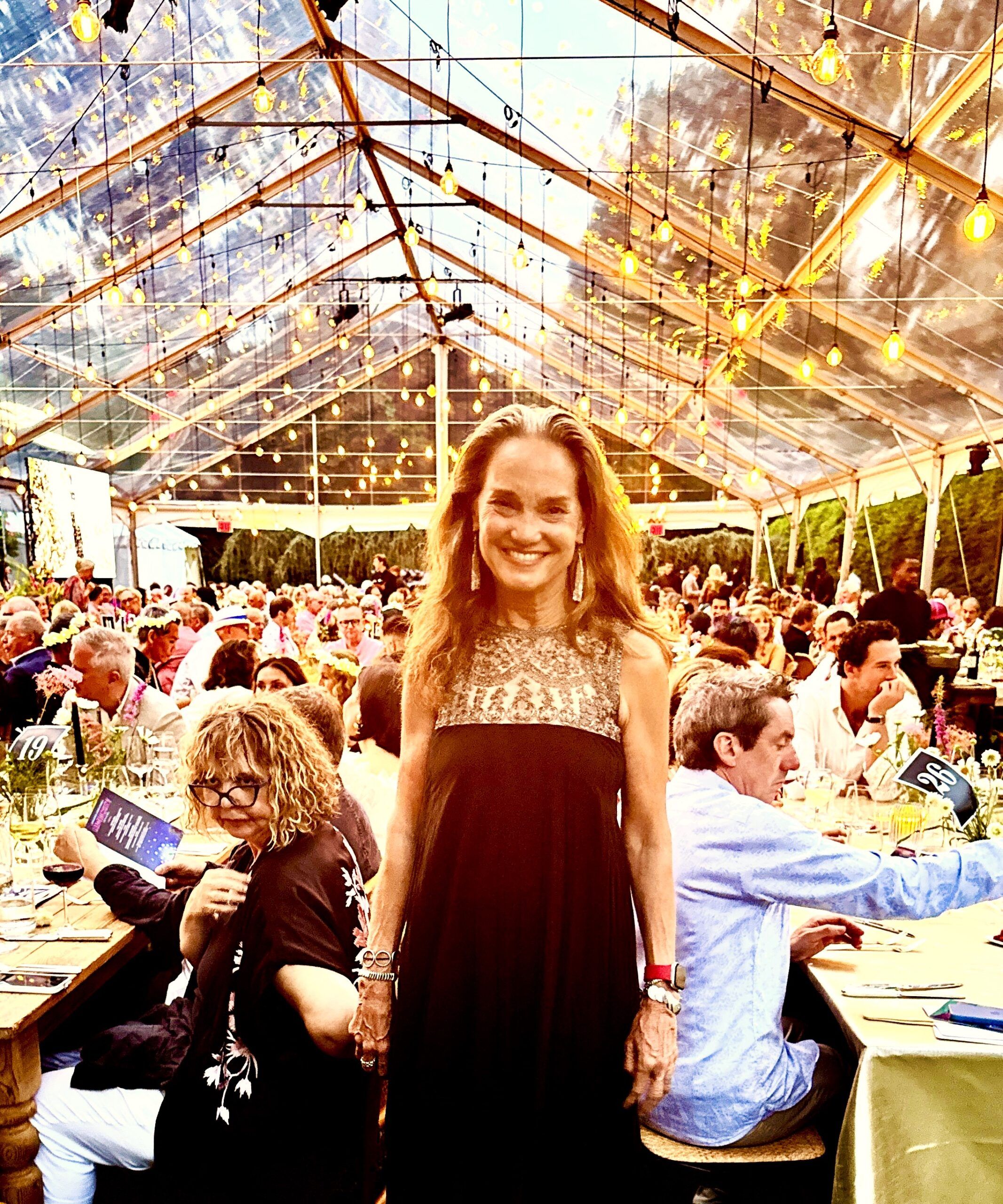 Woman smiling at outdoor dinner party under tent