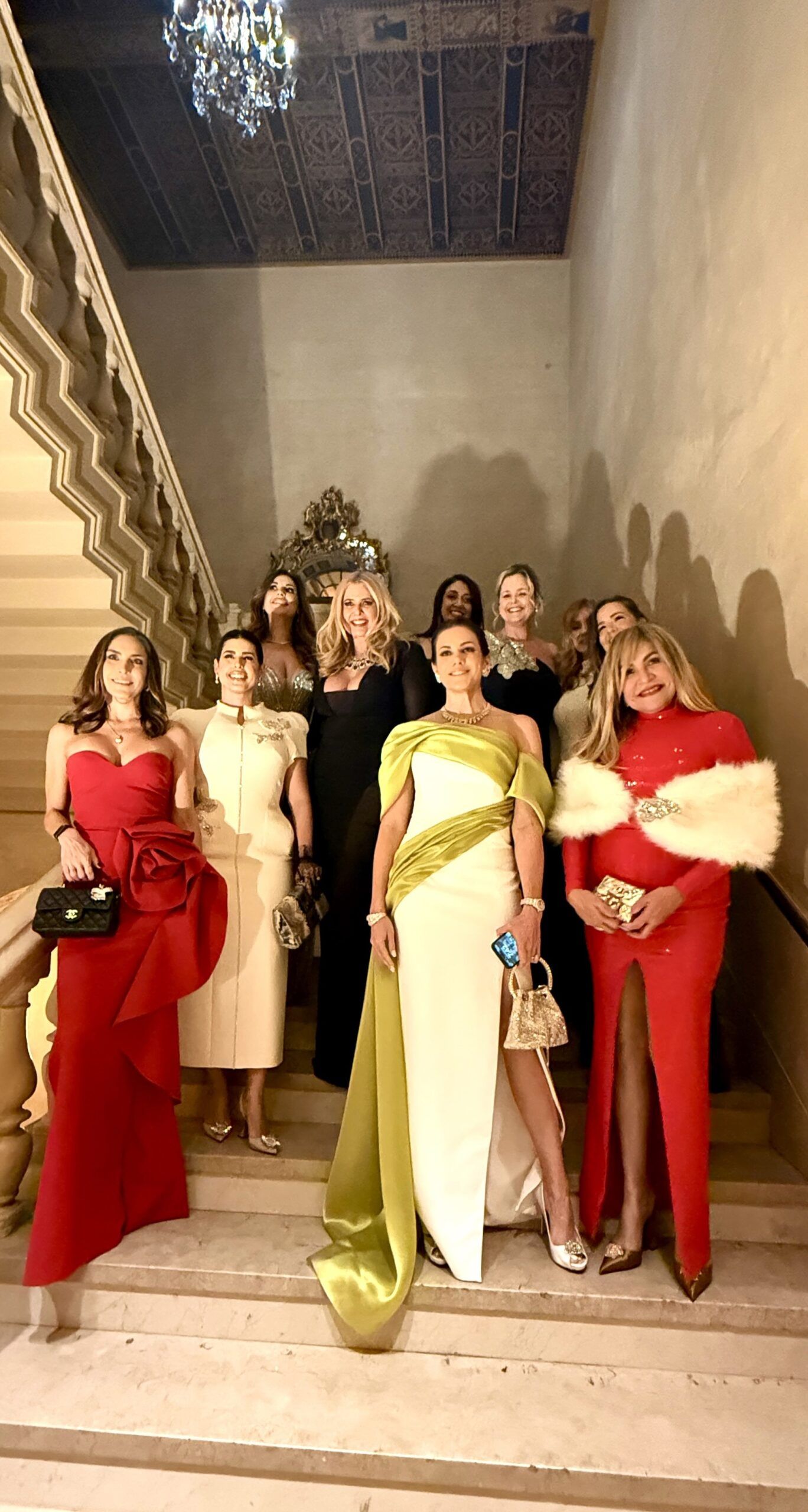 Group of women in formal gowns on staircase