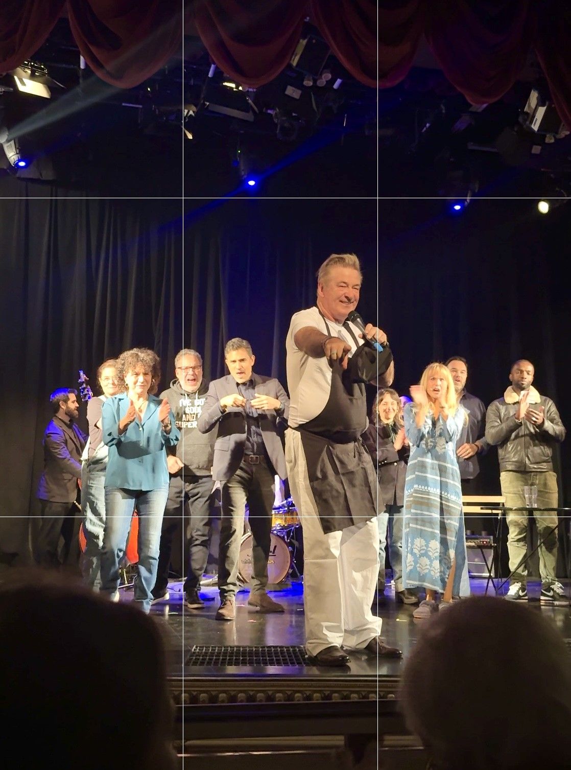 Man pointing to audience on stage with performers