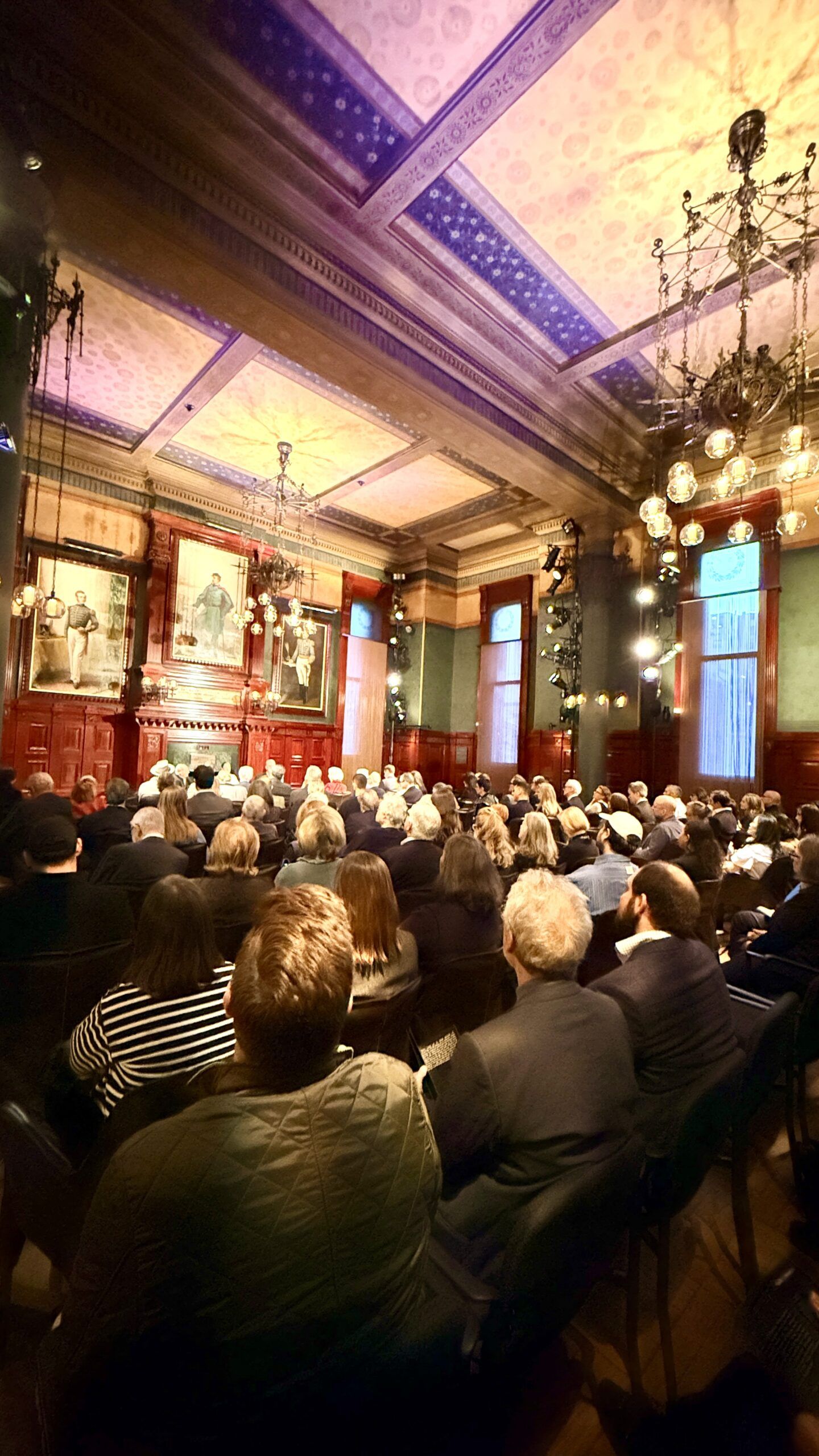Audience seated in ornate historic lecture hall