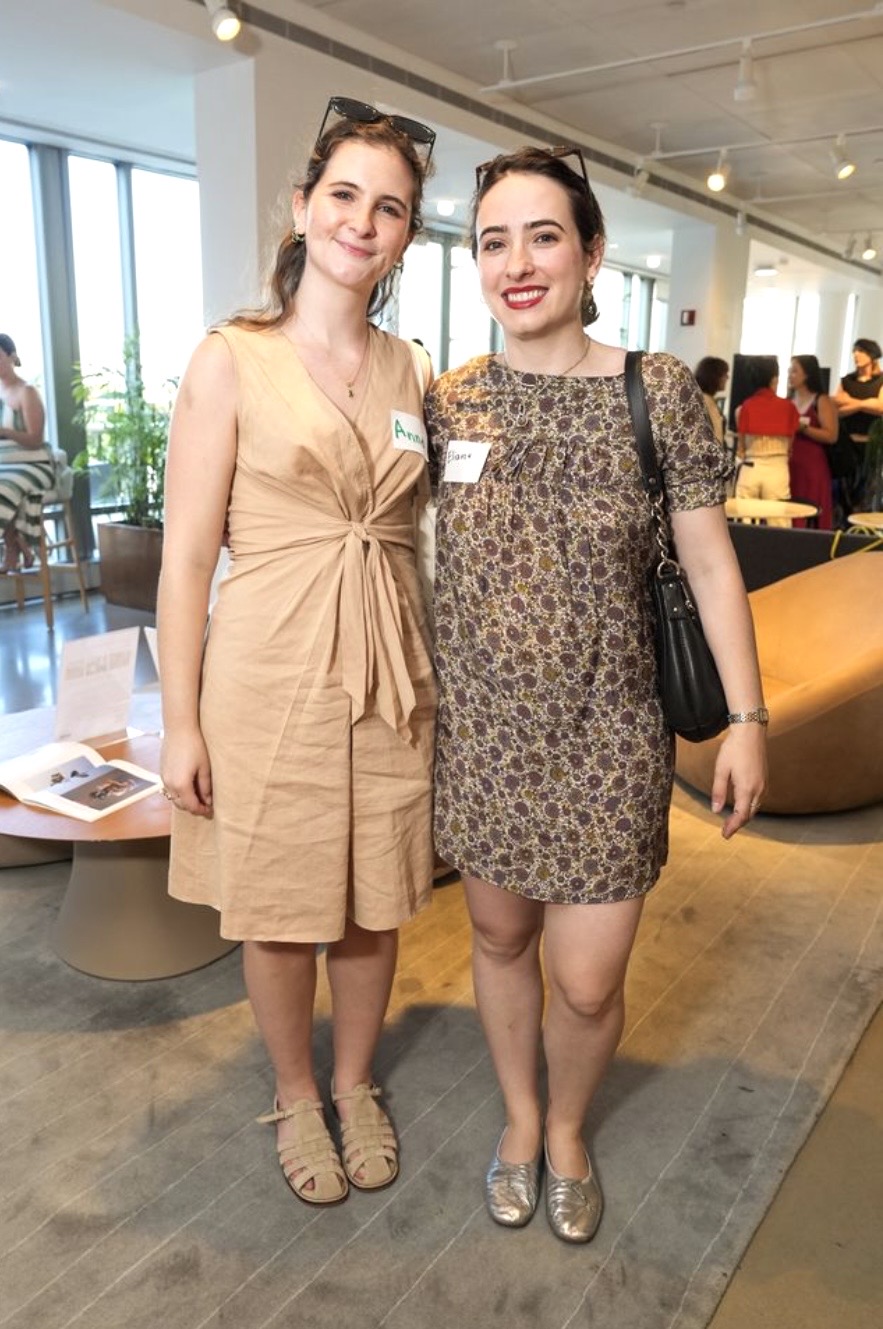 Two smiling women posing indoors at event