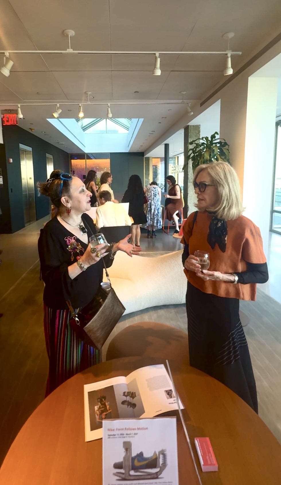 Two women talking at indoor social event