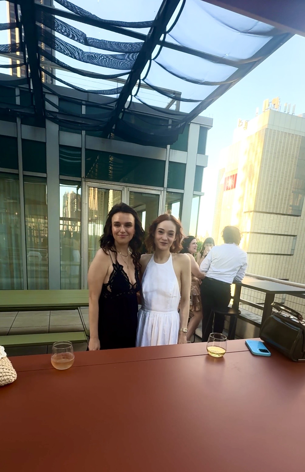 Two women on rooftop terrace with drinks