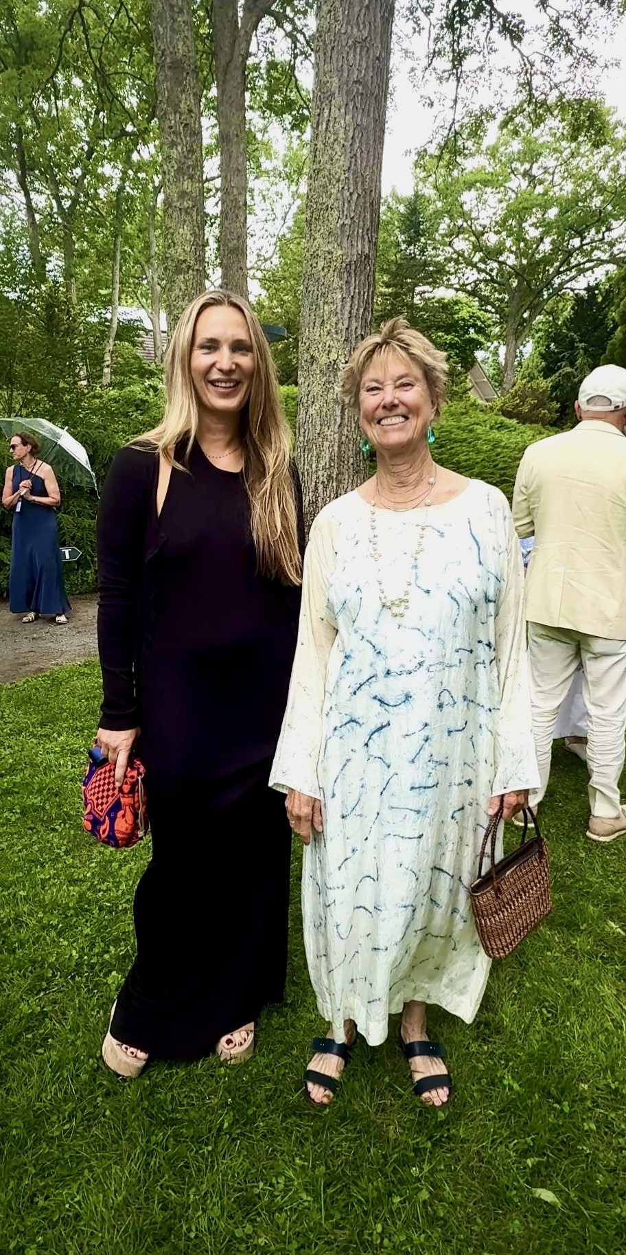Two women in dresses smiling outdoors