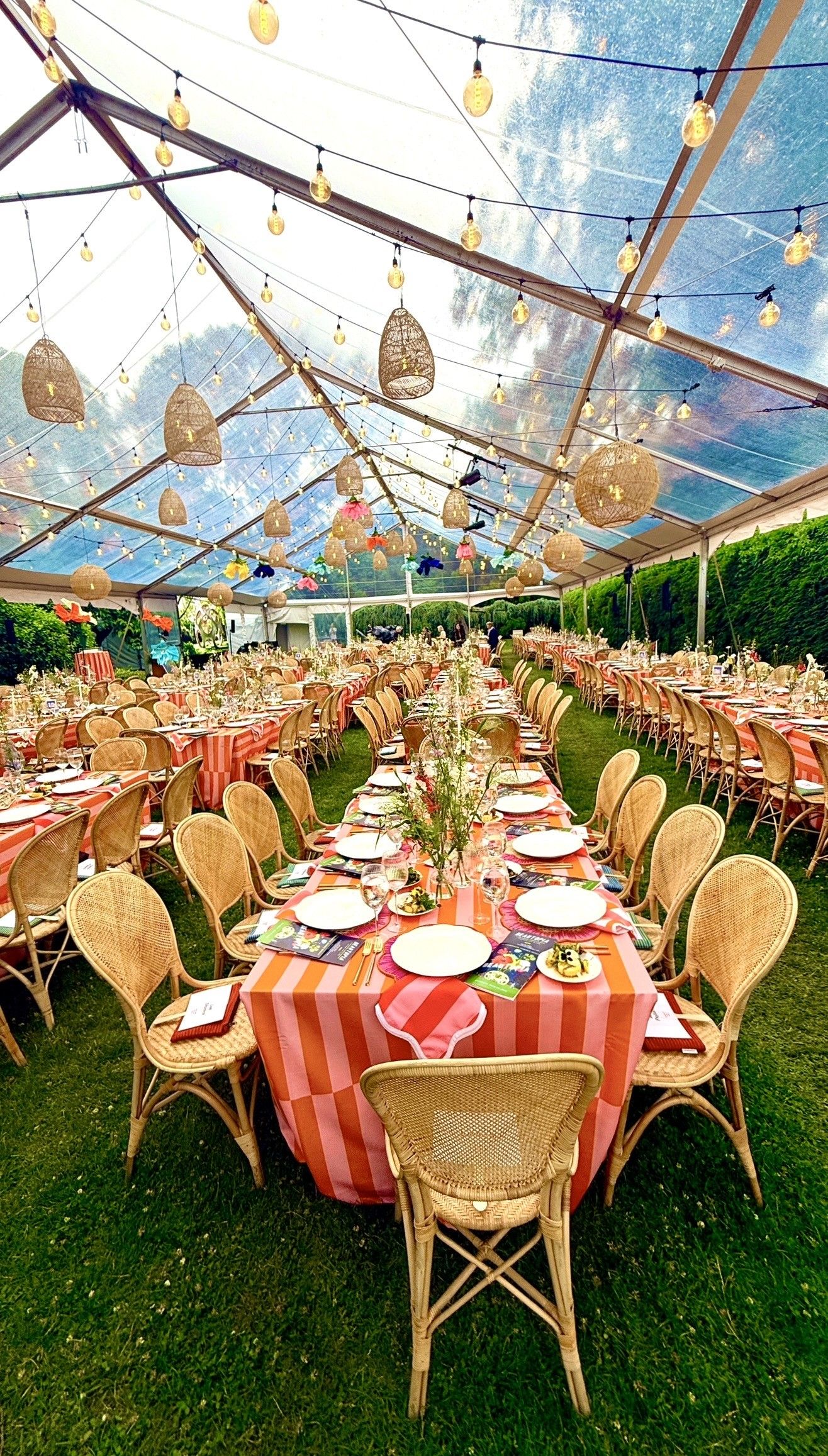 Long banquet tables under clear tent lights