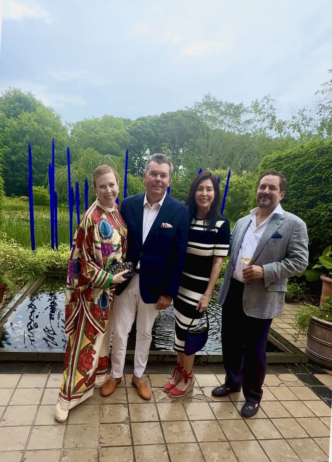 Group portrait in garden by blue sculpture pond