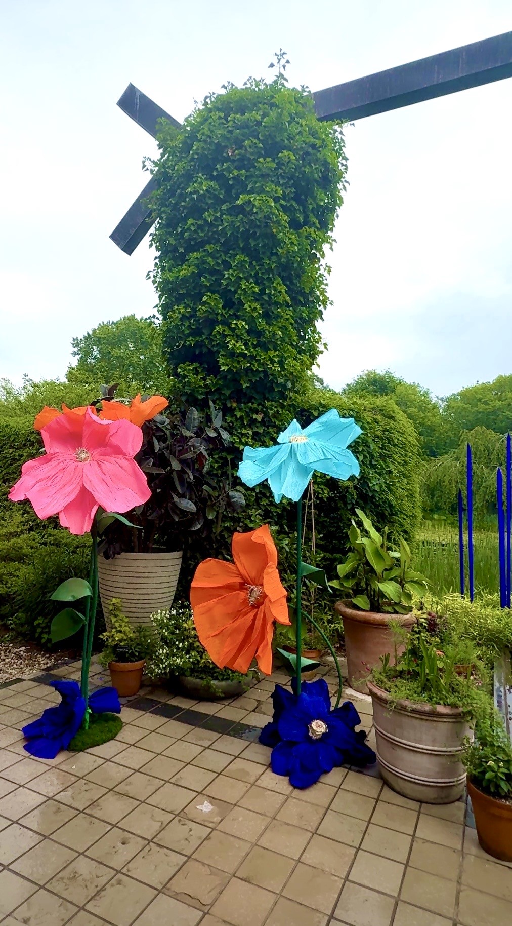 Giant colorful flowers near ivy-covered windmill