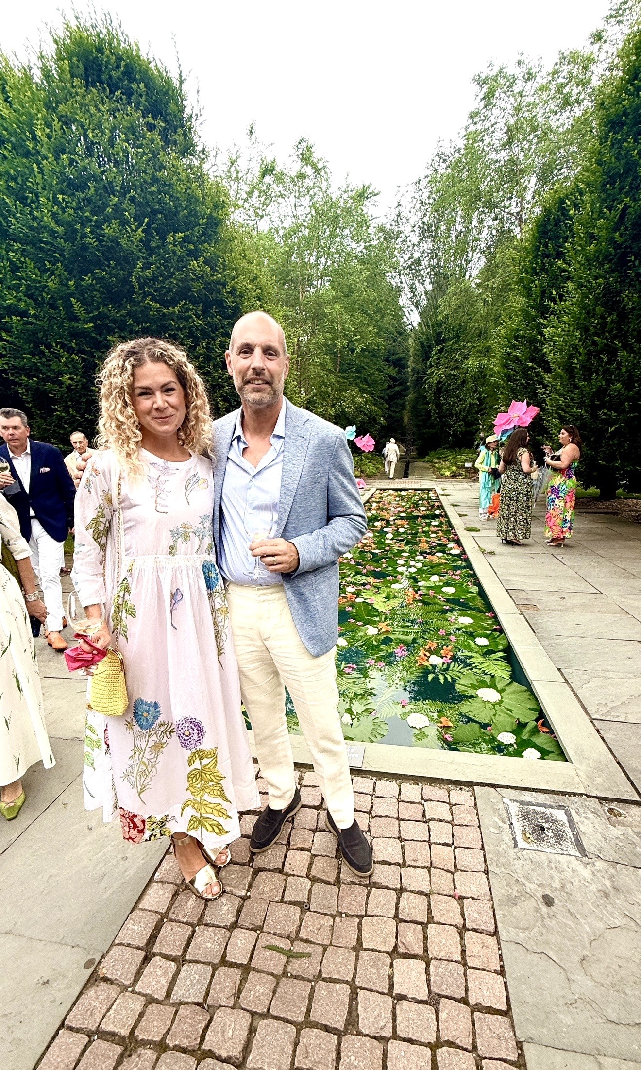Couple posing by lily-pad pond in garden