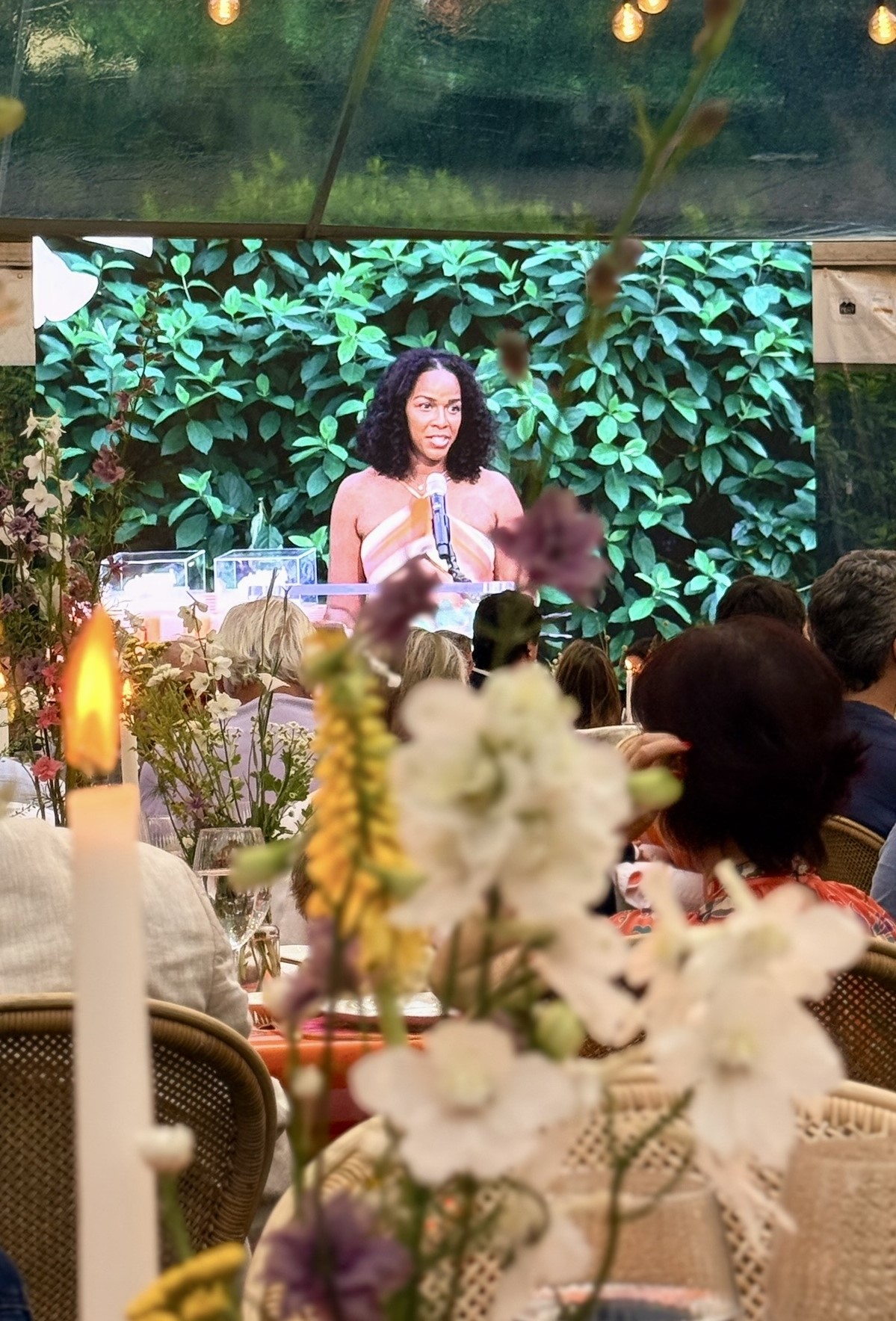 Woman speaking on stage at floral event