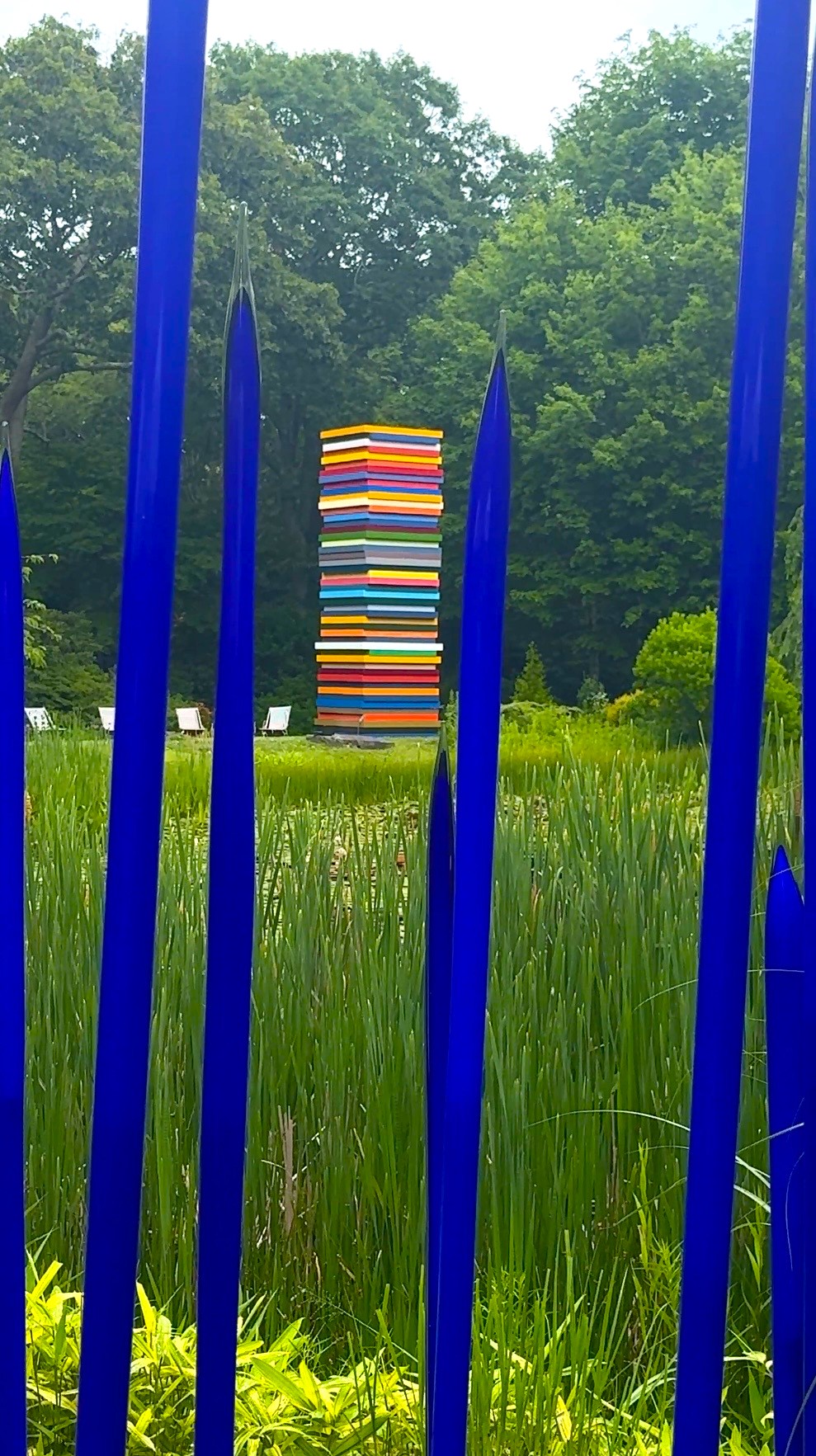 Blue glass rods framing colorful stacked sculpture